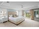 Spacious main bedroom boasts tray ceilings, plush carpet, and private balcony overlooking lush landscaping at 5004 W Leona St, Tampa, FL 33629