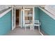 Covered porch features a seating area and charming blue siding at 5004 W Leona St, Tampa, FL 33629