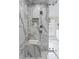 Walk-in shower featuring marble tile, recessed shelving, and multiple shower heads at 5004 W Leona St, Tampa, FL 33629