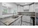 Modern kitchen with white cabinets, granite countertops, and stainless steel appliances at 670 16Th S Ave, St Petersburg, FL 33701