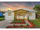 Beautiful single-story home featuring a covered porch and professionally landscaped front yard at dusk at 712 E Madison St, Plant City, FL 33563