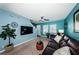 Living area featuring teal walls, dark leather furniture, and a large TV at 8010 Larriott Dr, Largo, FL 33773