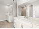 Bathroom with double vanity, stone countertops, and a glass shower at 11971 Starbright Path, Venice, FL 34293