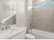 Stylish bathroom featuring modern tile, white vanity with sink, and shower-tub combination at 11971 Starbright Path, Venice, FL 34293