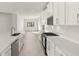 Contemporary kitchen featuring white cabinets, stainless steel appliances, quartz countertops, and light tile flooring at 11971 Starbright Path, Venice, FL 34293