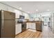 Modern kitchen featuring stainless steel appliances, granite countertops, and white cabinets with warm wood plank flooring at 12000 Gulf Blvd # 208-S, Treasure Island, FL 33706