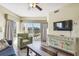 Living room with blue sofa, green chair, and balcony view at 12000 Gulf Blvd # 208-S, Treasure Island, FL 33706