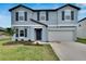 Two-story house with gray exterior, white garage door, and gray shutters at 12783 Maple Bonsai Dr, Riverview, FL 33579