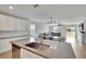 Modern kitchen with white cabinets, granite countertops, island, and stainless steel appliances at 12783 Maple Bonsai Dr, Riverview, FL 33579