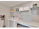 Bright laundry room with washer, dryer, and ample shelving at 12783 Maple Bonsai Dr, Riverview, FL 33579