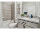 Bathroom with gray tile shower/tub combo, granite countertop, and gray cabinets at 15354 Sweet Springs Bnd, Odessa, FL 33556