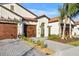 Two-story home with tile roof, two-car garage, and landscaped yard at 17523 Holly Well Ave, Wimauma, FL 33598