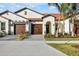 Two-story home with tile roof, two-car garage, and landscaped yard at 17523 Holly Well Ave, Wimauma, FL 33598