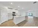 Open kitchen features stainless steel appliances and an island overlooking the living room at 17523 Holly Well Ave, Wimauma, FL 33598