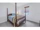 Charming bedroom with a four-poster bed and window with bamboo shade at 2204 W Horatio St, Tampa, FL 33606