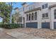 Another view of the charming three story home with gray garage doors and a brick driveway at 2204 W Horatio St, Tampa, FL 33606