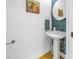 Powder room with pedestal sink, blue tile, and sea turtle art at 2204 W Horatio St, Tampa, FL 33606