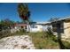 Backyard with a small patio and overgrown landscaping at 249 Boca Ciega Dr, Madeira Beach, FL 33708