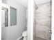Updated bathroom with a walk-in shower and grey tile at 249 Boca Ciega Dr, Madeira Beach, FL 33708