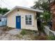 Light yellow house with blue door and small yard at 249 Boca Ciega Dr, Madeira Beach, FL 33708