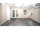 Spacious living area with wood-look tile floors and double French doors at 249 Boca Ciega Dr, Madeira Beach, FL 33708