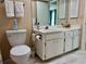 Bathroom featuring white cabinetry, a toilet, and a large mirror at 2740 Highlands Blvd # D, Palm Harbor, FL 34684