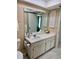 Tiled bathroom with a large vanity and mirror at 2740 Highlands Blvd # D, Palm Harbor, FL 34684