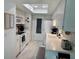 Galley-style kitchen with white appliances, a skylight, and ample counter space at 2740 Highlands Blvd # D, Palm Harbor, FL 34684