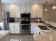 Modern kitchen with white cabinets, marble countertops, and stainless steel appliances at 3001 58Th S Ave # 610, St Petersburg, FL 33712