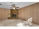 Cozy living room with wood paneling, stone fireplace, and ceiling fan at 4403 Northrop Ter, Tampa, FL 33618