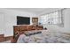 Bedroom with a patterned bedspread, wood dresser, wall-mounted TV, and window with lace curtains at 4600 16Th N St, St Petersburg, FL 33703