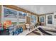 Sunroom with many windows, wood-paneled walls, outdoor access, small sofa, and storage items at 4600 16Th N St, St Petersburg, FL 33703