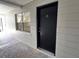 Condo building entrance with black door and gray brick at 5221 Bayshore Blvd # 15, Tampa, FL 33611