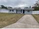 Newly renovated 1950s home with gray exterior, new landscaping, and a long driveway at 5700 38Th N Ave, St Petersburg, FL 33710