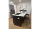 Kitchen island with a quartz countertop, dark lower cabinets, and bar stools at 5700 38Th N Ave, St Petersburg, FL 33710