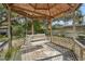 Covered gazebo with white swing and wood flooring at 6103 E 112Th Ave, Temple Terrace, FL 33617