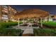 Night view of community BBQ area with thatched roof at 634 Edgewater Dr # 447, Dunedin, FL 34698
