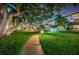 Lush courtyard with a walkway, landscaping, and building at night at 634 Edgewater Dr # 447, Dunedin, FL 34698