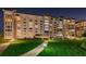 Night view of a well-lit condo building with landscaping at 634 Edgewater Dr # 447, Dunedin, FL 34698
