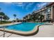 Community pool with building in background at 634 Edgewater Dr # 447, Dunedin, FL 34698