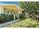 Front view of a yellow house with a porch and landscaping at 809 E Lambright St, Tampa, FL 33604