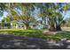 House with a lush lawn, large trees, and a pergola at 8390 64Th N St, Pinellas Park, FL 33781