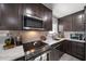 Modern kitchen with dark cabinets, stainless steel appliances, and marble countertops at 8390 64Th N St, Pinellas Park, FL 33781