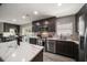 Modern kitchen with dark cabinetry, marble countertops, and stainless steel appliances at 8390 64Th N St, Pinellas Park, FL 33781