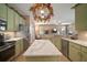 Eat-in kitchen with island, stainless steel appliances, and green cabinets at 8607 Tidal Breeze Dr, Riverview, FL 33569