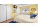 Bright bedroom with white dressers, TV, ceiling fan, and coastal decor with matching area rug at 9901 1St E St # F, Treasure Island, FL 33706