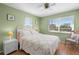 Cozy bedroom with a bed with floral bedding, white wicker nightstand and a window view at 9901 1St E St # F, Treasure Island, FL 33706