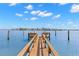 Beautiful wood dock extending into the blue waters of the harbor on a sunny day at 9901 1St E St # F, Treasure Island, FL 33706
