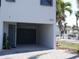Exterior view of the carport and entrance to the home with palm trees in the background at 9901 1St E St # F, Treasure Island, FL 33706