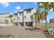 Three-story building with paved courtyard and tropical landscaping at 9901 1St E St # F, Treasure Island, FL 33706